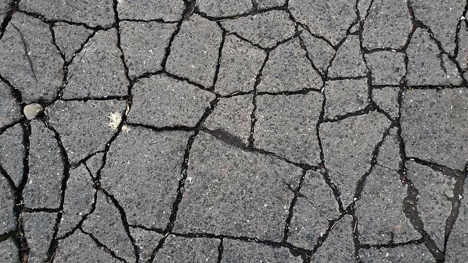 A patch of alligator cracking breaking an asphalt surface into small angular blocks