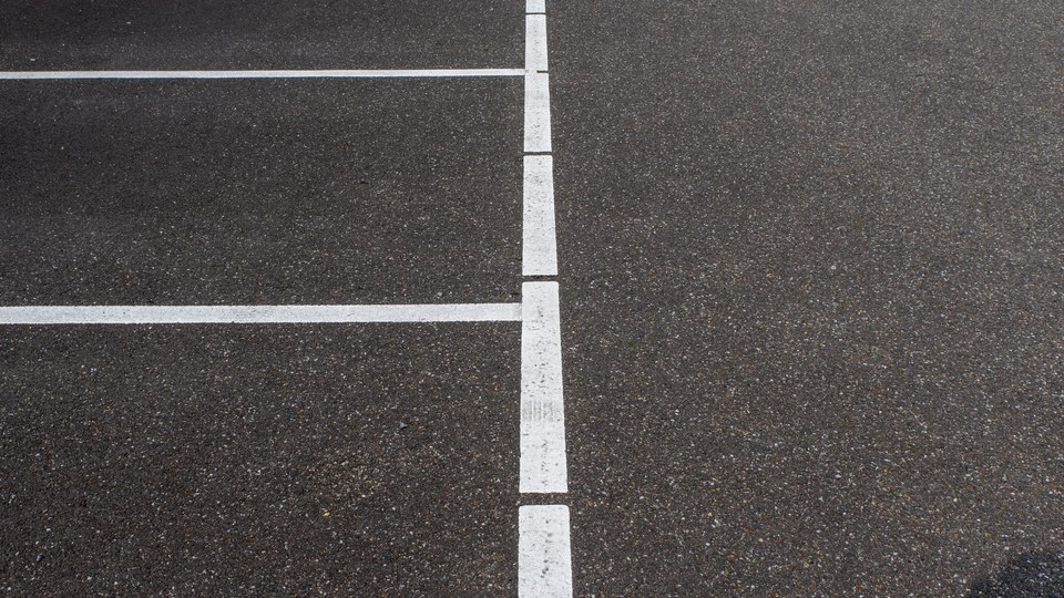 Crisp white stall striping laid out across a dark asphalt parking lot